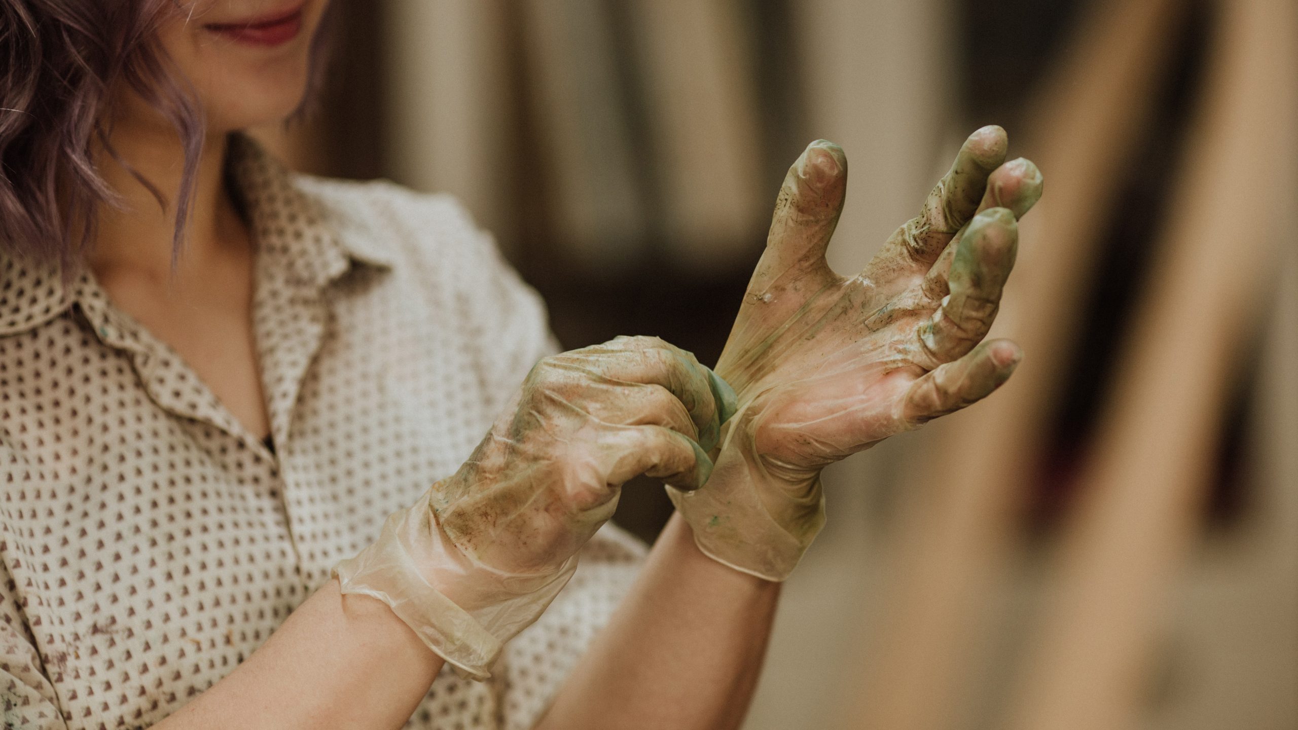 A woman putting on gloves for painting