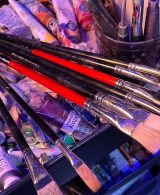 Brushes set against the background of oil paint tubes